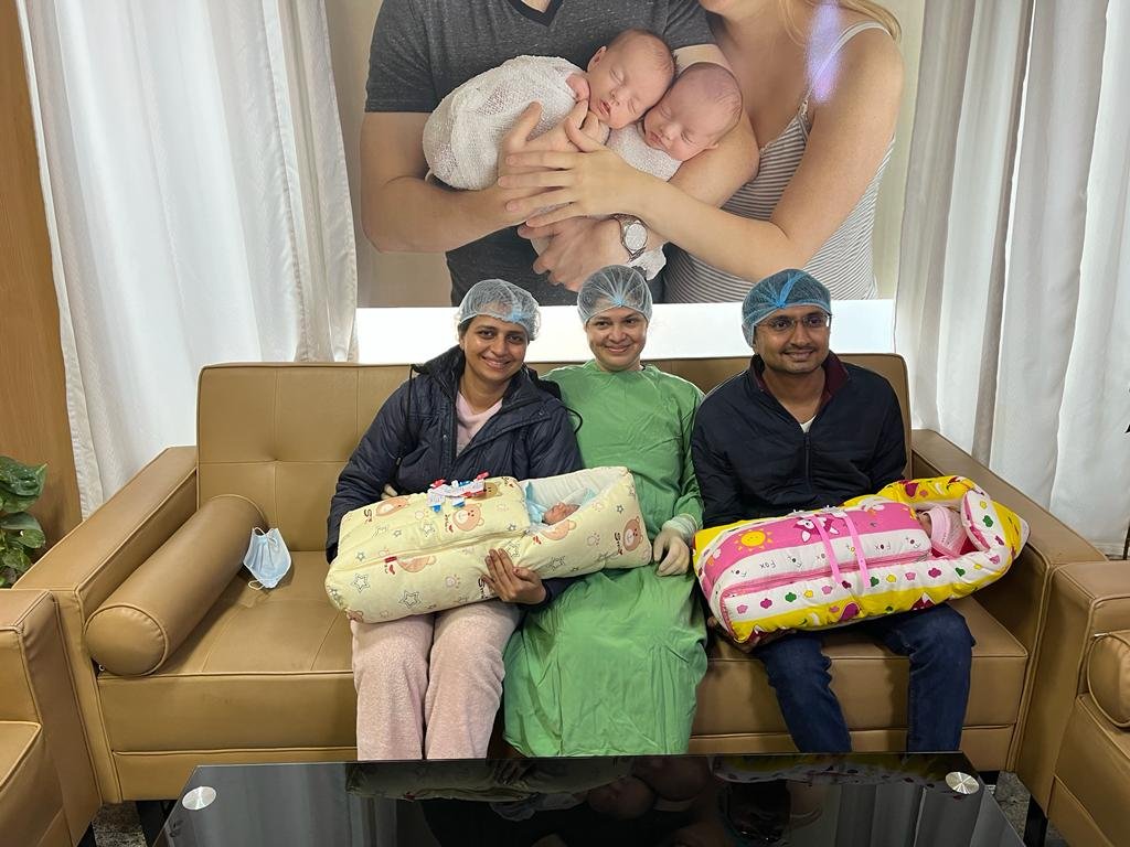 Family with newborn twins and their doctor
