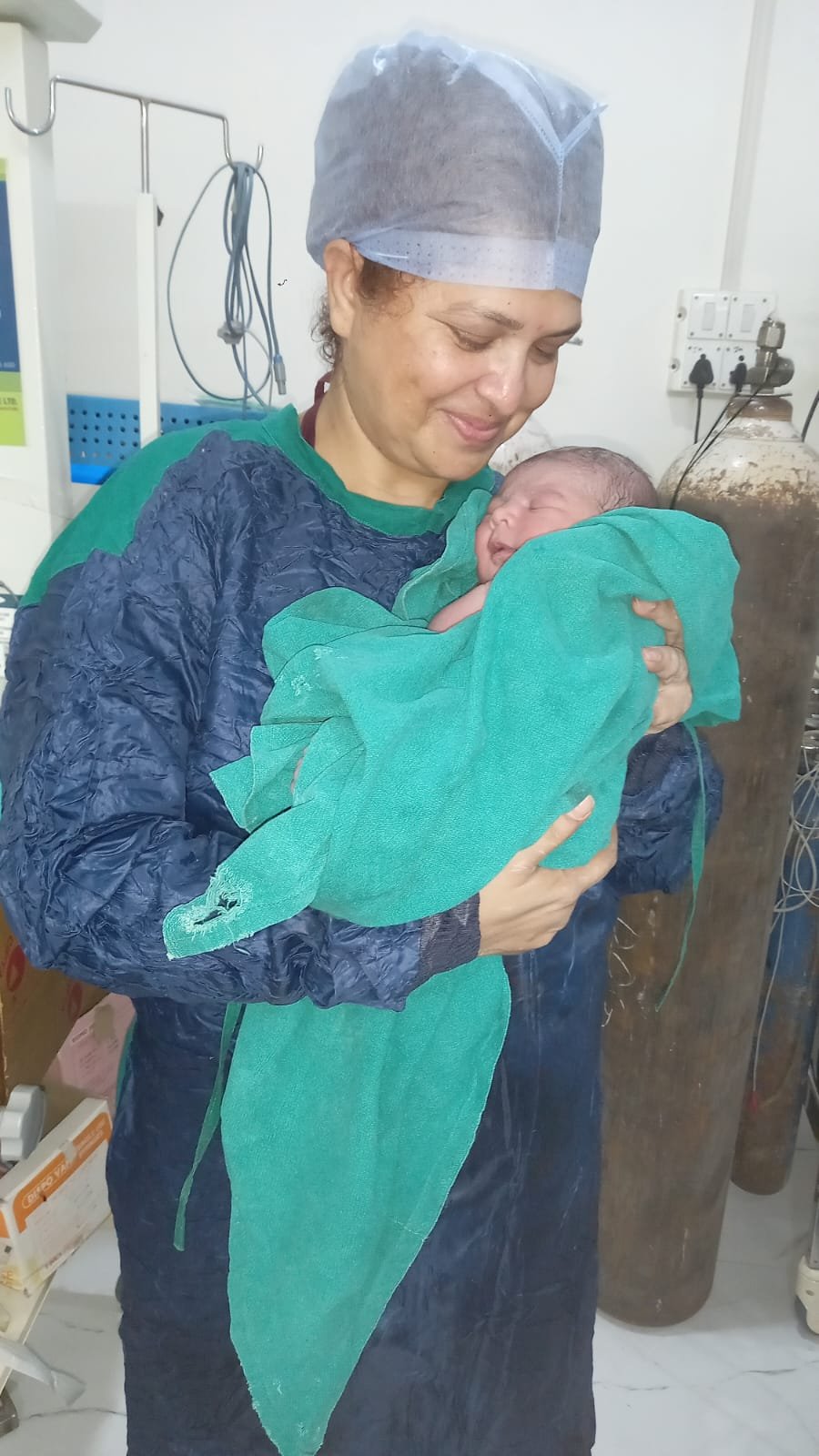 Newborn baby held by clinical staff